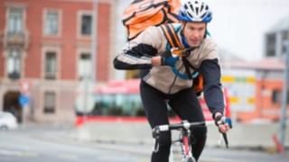 Kurier liefert Pakete mit dekm Fahrrad aus. Kurier unterwegs auf einem Fahrrad